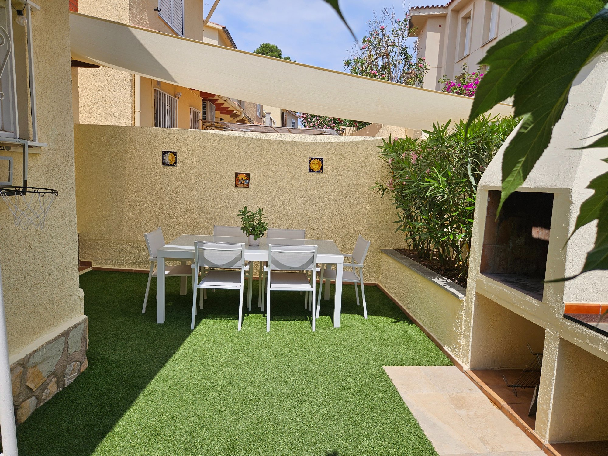 Patio con barbacoa de obra y toldo